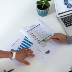 Zwei Frauen schauen sich ausgedruckte Reports an.