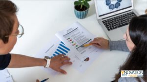 Zwei Frauen schauen sich ausgedruckte Reports an.