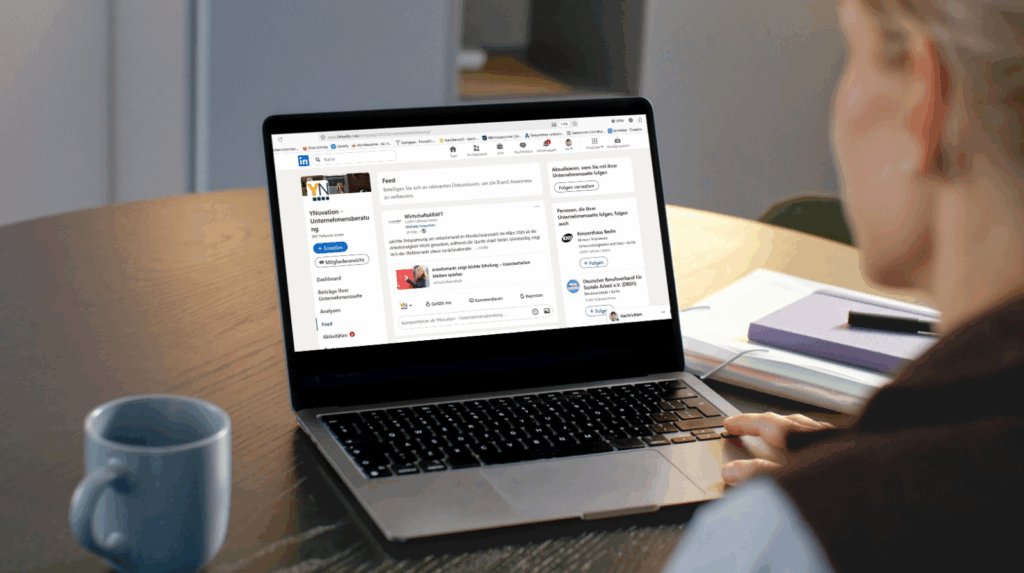 Eine Frau schaut auf einen Laptop. Auf dem Bildschirm ist LinkedIn geöffnet.